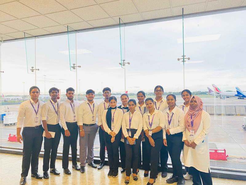 MCAS students at an airport window overlooking aircraft