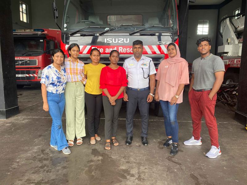 MCAS students beside a fire engine at an airport fire station